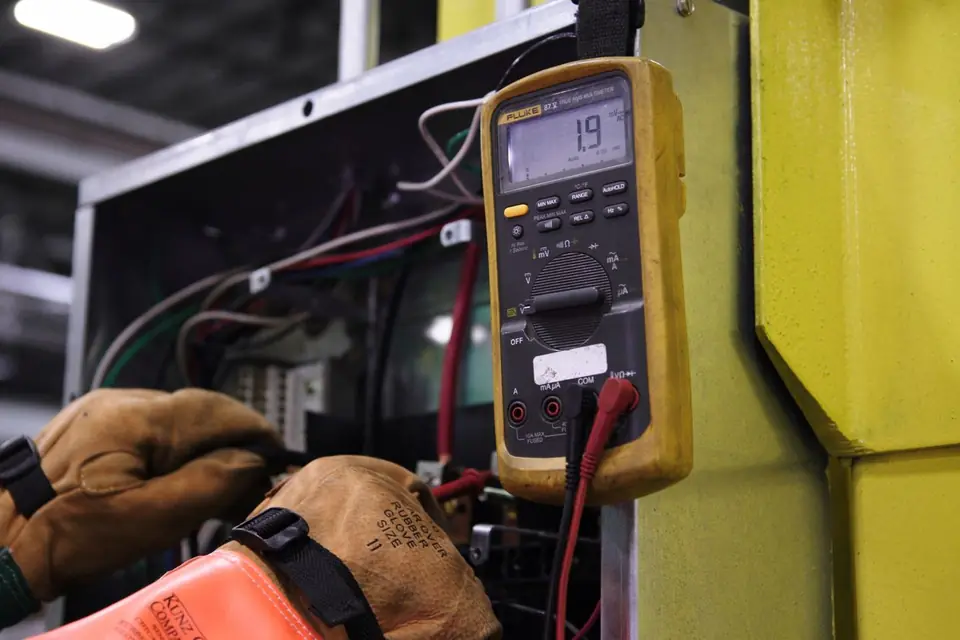 Electrician testing a domestic consumer unit with a multimeter