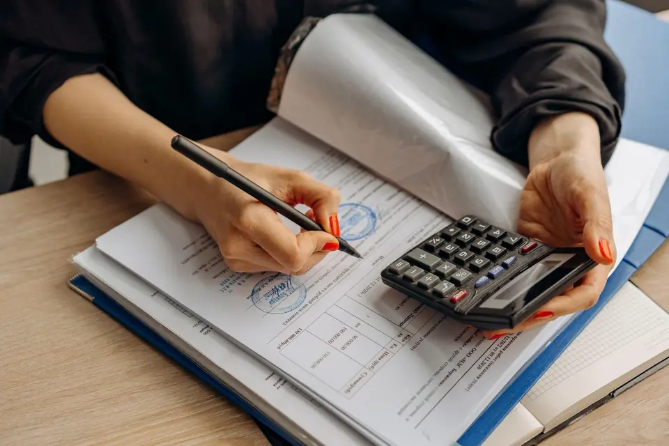 Bills, a calculator and paperwork on a desk