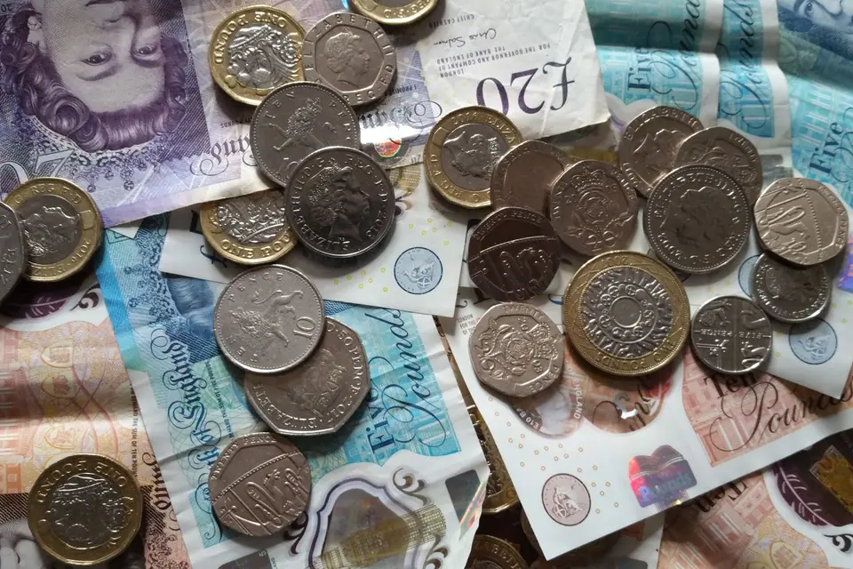 A set of house keys handed over above some bank notes