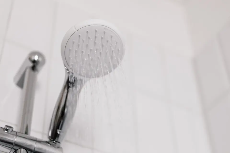 A chrome shower head on a tiled bathroom wall