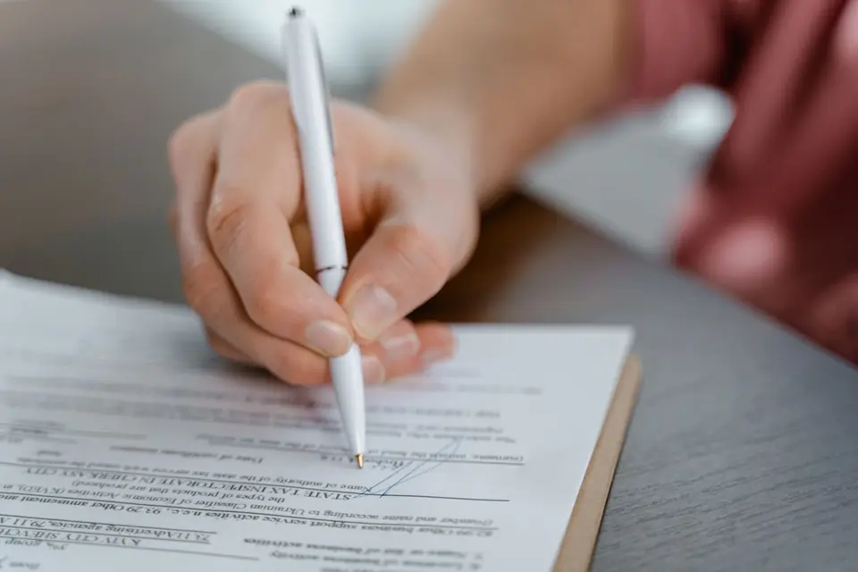 A tenancy agreement being signed with a set of keys on the table